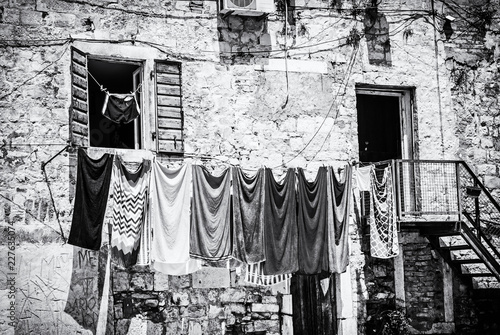 Drying clothes in front of the old house, colorless