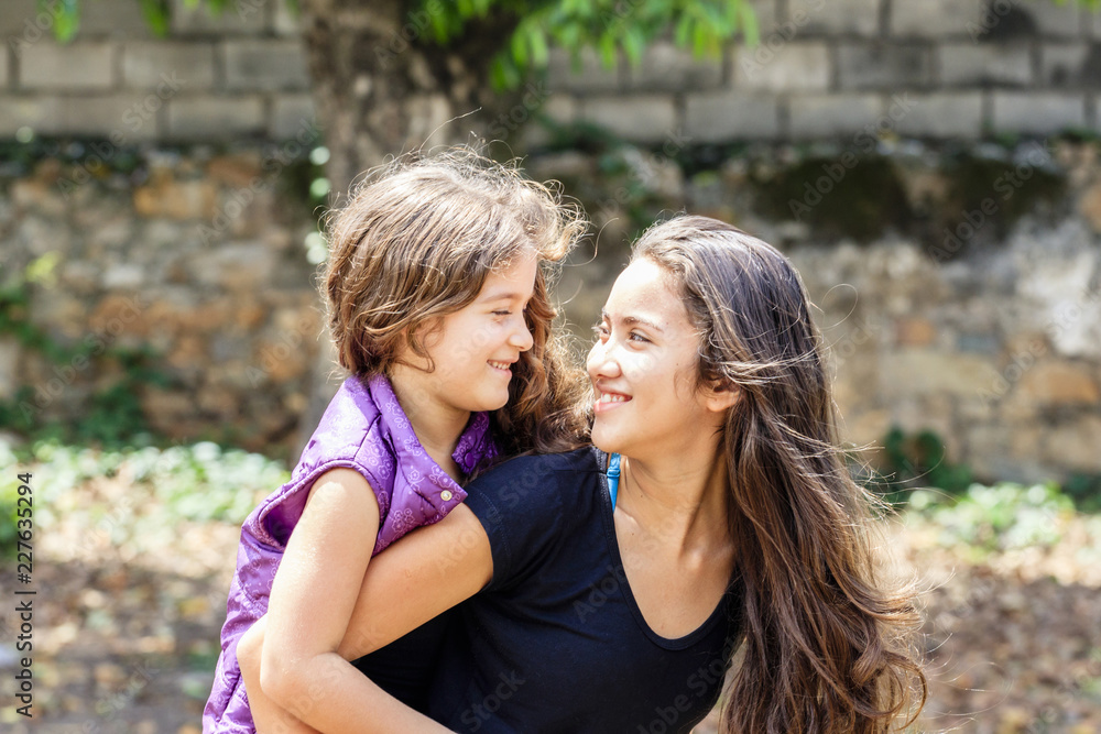 Portrait of sisters having fun together on sunny day outdoors Portrait of sisters having fun together on sunny day outdoors