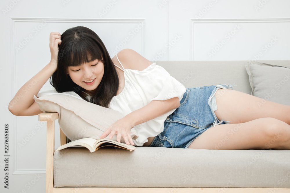Young woman reading book at home with happy smiley face and relaxation posture, lay in warm and cozy house. However, maybe it's bad posture. Young woman reading book at home with happy smiley face and relaxation posture, lay in warm and cozy house. However, maybe it's bad posture.