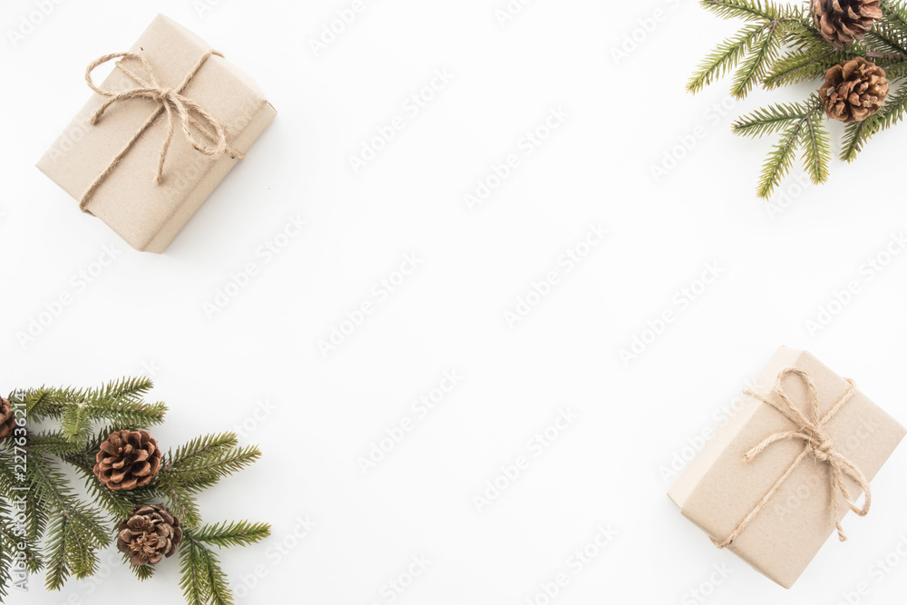 Gift boxes with pine branches and pine cones are on top of white desk table during Christmas or new year. Top view with copy space, flat lay. Gift boxes with pine branches and pine cones are on top of white desk table during Christmas or new year. Top view with copy space, flat lay.