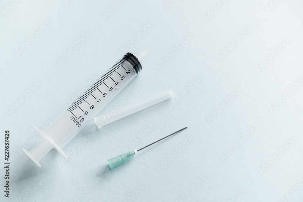 Transparent syringe with a needle, on a background. No liquid in the syringe. Single use only. Transparent syringe with a needle, on a background. No liquid in the syringe. Single use only.