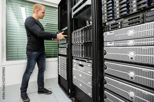 Male Technical Consultant Installing Router In SAN At Datacenter