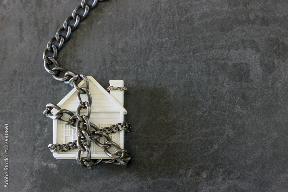 House in chains. Concept - risks, lose property, seize, mortgage. House in chains. Concept - risks, lose property, seize, mortgage.