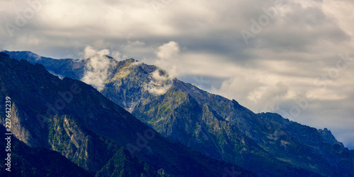 Clouds over the tops of the rocky mountains. Photographed in the Caucasus, Russia. © olgapkurguzova