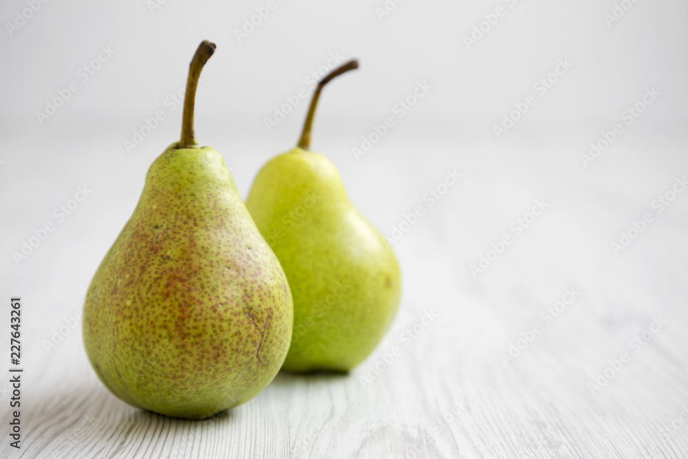 Fresh pears on a white wooden surface, side view. Close-up. Space for text. Fresh pears on a white wooden surface, side view. Close-up. Space for text.