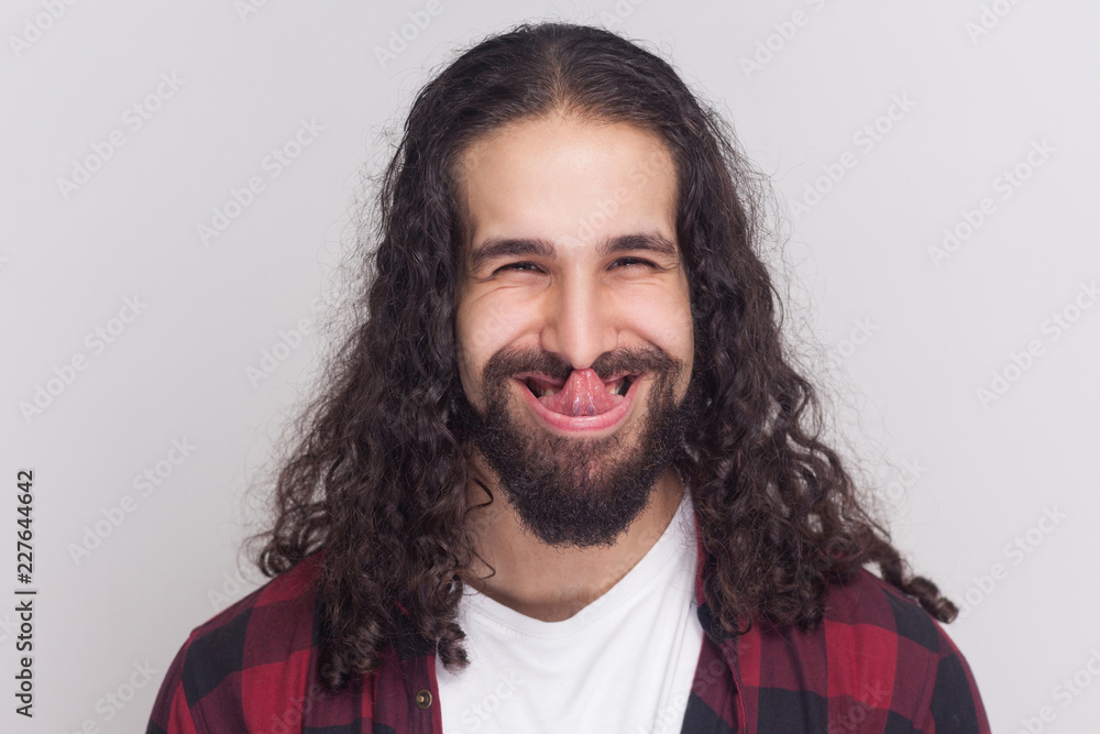 Funny crazy brunette man with beard and black long curly hair in casual  style, checkered red