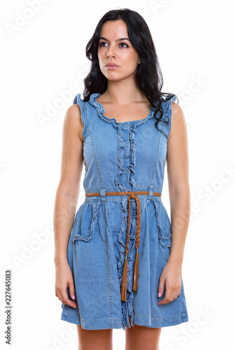 Studio shot of young beautiful Spanish woman standing and thinki photo