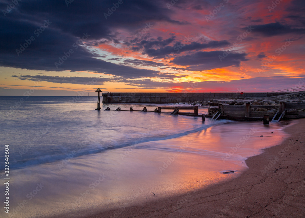 Sunrise over Seaton Sluice Beach and Harbour entrance on the coast of Northumberland, England, UK.