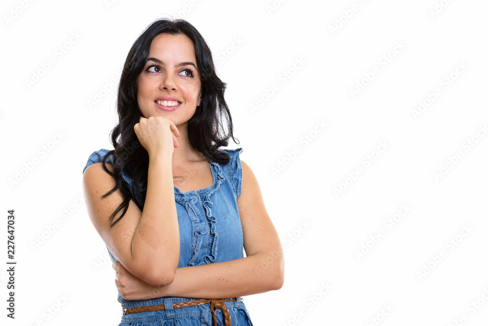 Studio shot of young happy Spanish woman smiling and thinking wh Studio shot of young happy Spanish woman smiling and thinking wh