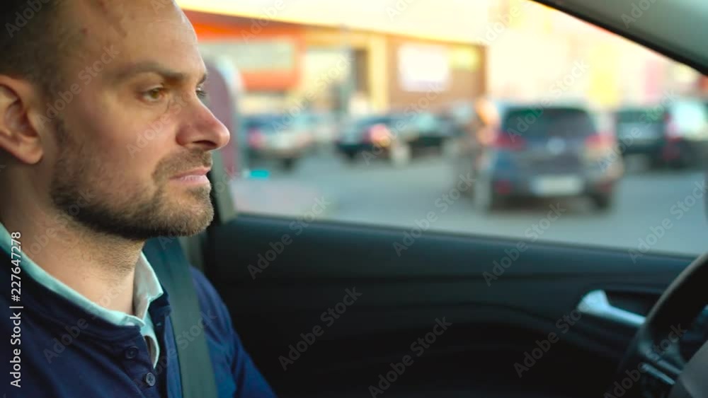 Man driving a car, looking for a place to park Man driving a car, looking for a place to park