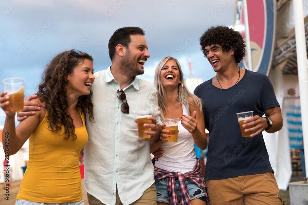 Fototapeta premium Enjoying beer with friends. Young people hanging out and enjoying drinks at music festival.