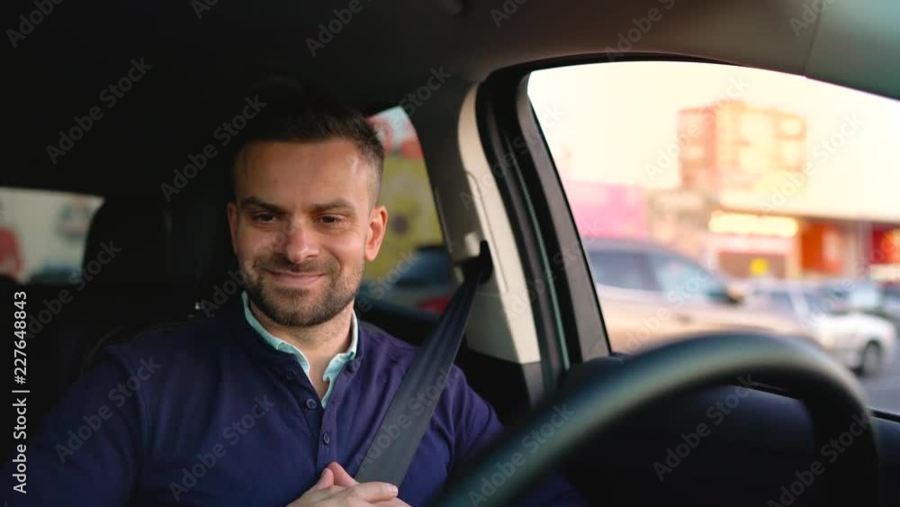 Emotional man driving in innovative automated car using self-parking autopilot for parking on street Emotional man driving in innovative automated car using self-parking autopilot for parking on street
