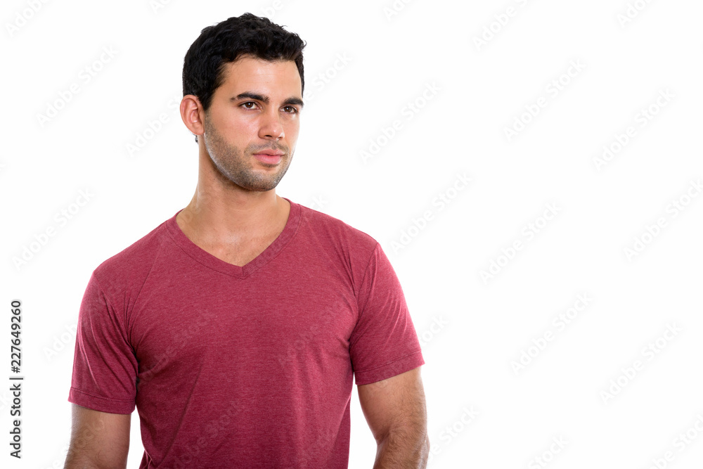 Studio shot of young handsome Hispanic man thinking while lookin Studio shot of young handsome Hispanic man thinking while lookin