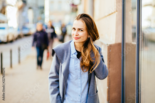 Brunette trendy woman portrait of young pretty trendy girl posing at the city in Europe, autumn street, laughing and smiling portrait.