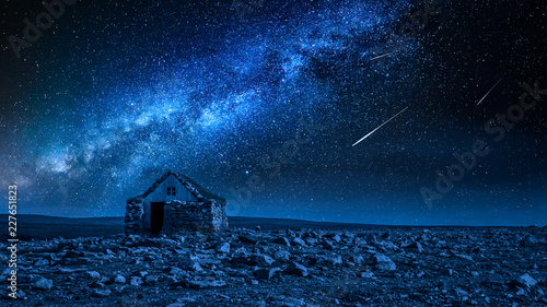 Small stone cottage and milky way with falling stars, Iceland