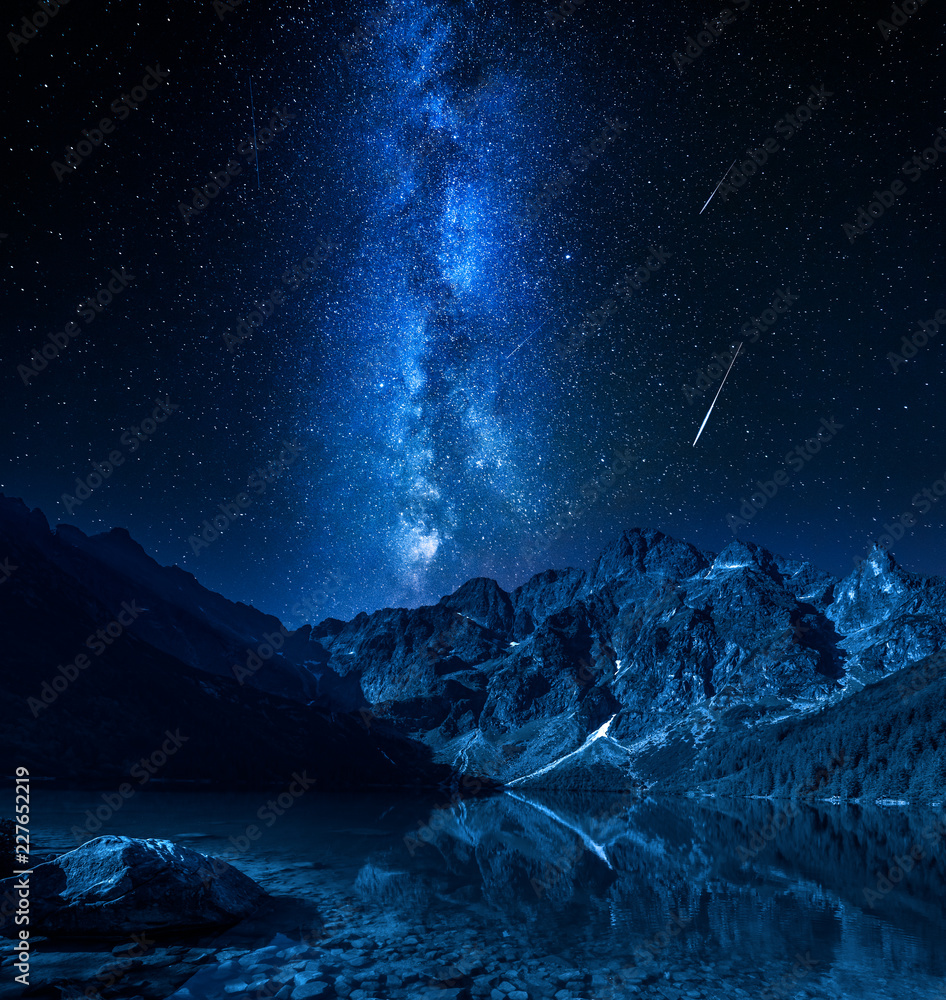 Naklejka premium Milky way and falling stars at mountains lake, Poland, Europe