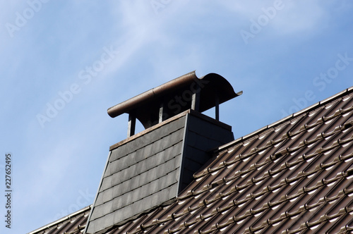 Schornstein mit Regenschutz auf dem Dach
