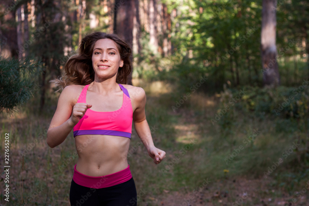 Young female runs in morning forest