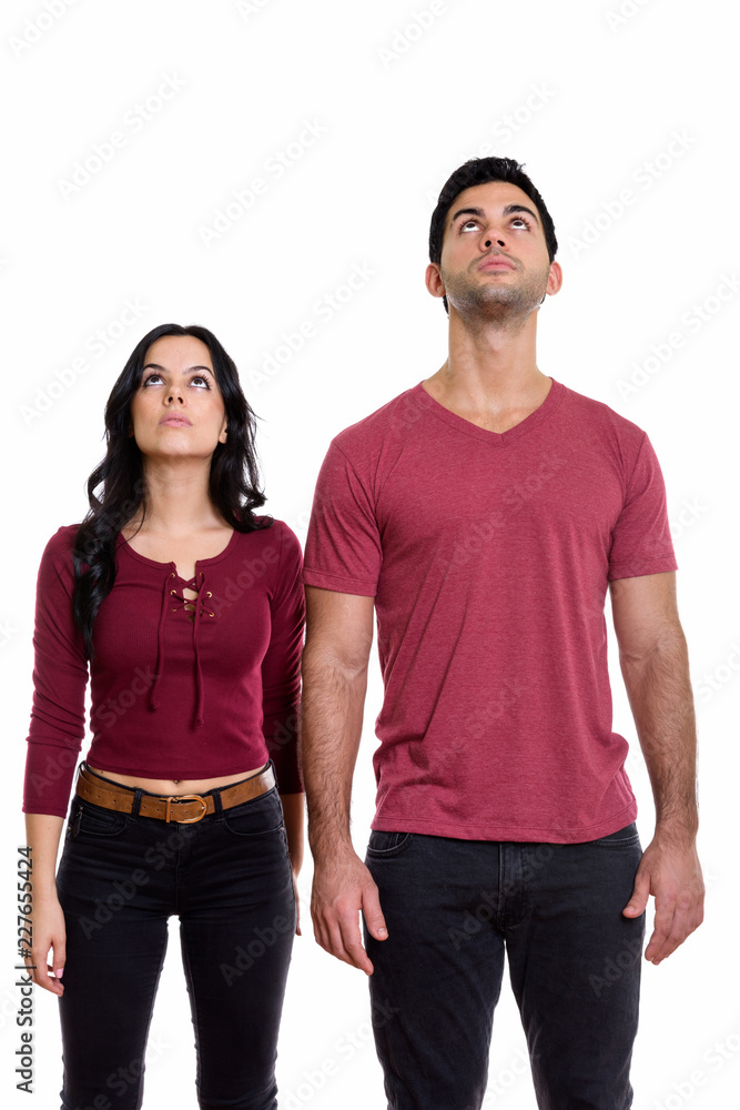 Studio shot of young couple standing and looking up together Studio shot of young couple standing and looking up together