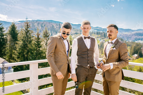 Wedding portrait groomsmen and groom. Young friends groomsman posing for camera. Cheerful friends outdoors. Wedding day.