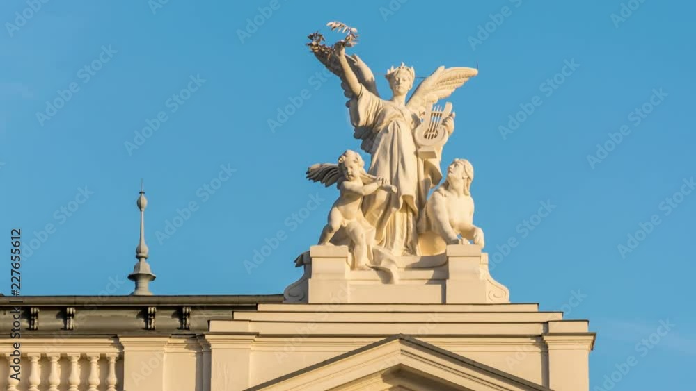 Close-up of Angle stutue at the rooftop of Zurich Opera house building. Daily Moon move across the blue sky and hide behind the statue. Golden hour, time lapse video. Close-up of Angle stutue at the rooftop of Zurich Opera house building. Daily Moon move across the blue sky and hide behind the statue. Golden hour, time lapse video.