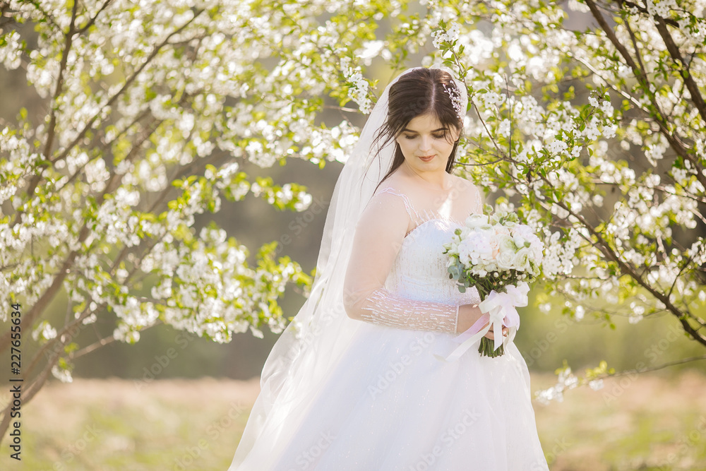 Pretty happy bride in luxury dress with bouquet of roses. Wedding photoshoot outdoor. Beautiful woman with wedding flowers. Pretty happy bride in luxury dress with bouquet of roses. Wedding photoshoot outdoor. Beautiful woman with wedding flowers.