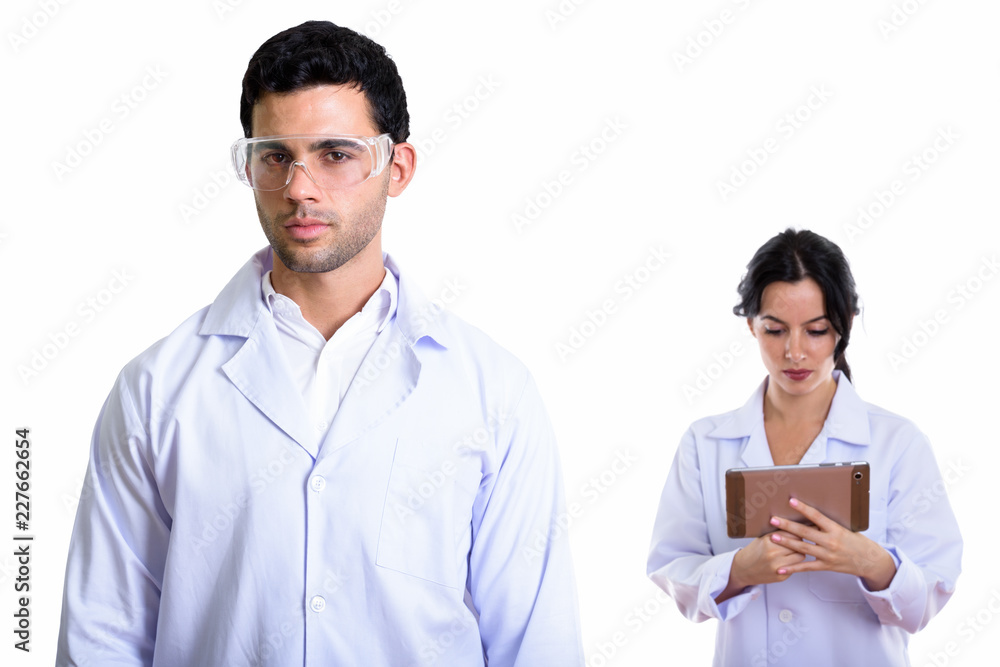 Studio shot of young man doctor wearing protective glasses and w Studio shot of young man doctor wearing protective glasses and w