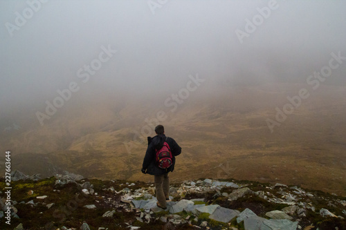 Man hiking in foggy moody Connemara national park in Ireland