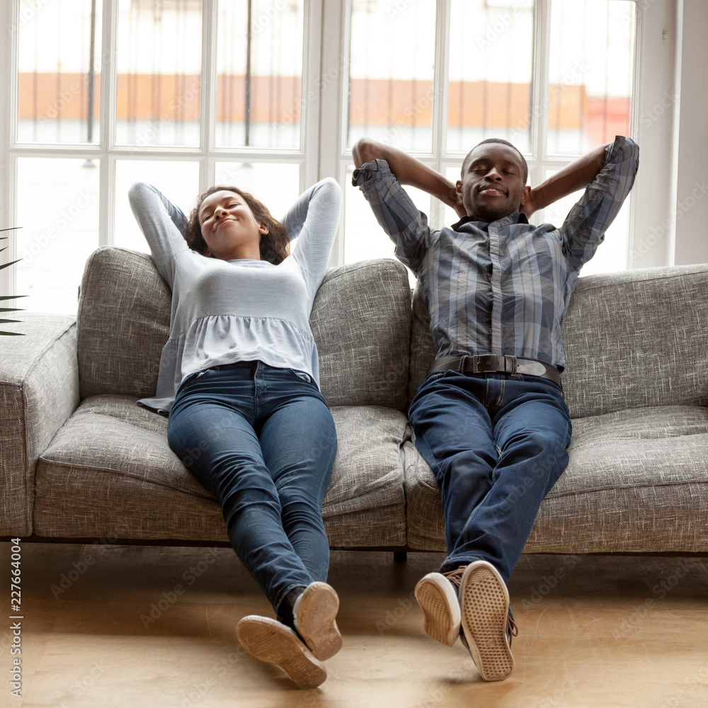 Black African married couple sitting on couch in living room at home ...