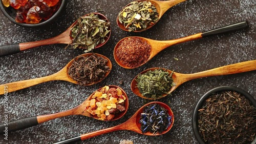 Wallpaper Mural Spoons with different types of dry tea leaves on rusty dark background. Top view. Torontodigital.ca