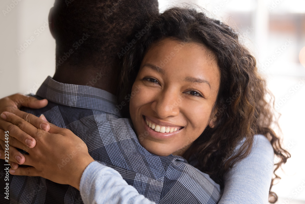 wife faciale Portrait of black beautiful wife embracing husband. Close up african woman looking at camera, man rear view Attractive affectionate couple in love, romantic relationship just a married engaged concept Photos | Adobe