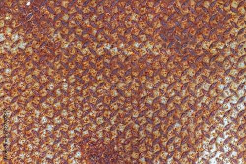 Background of scratching color and rusty on vintage steel checker plate with soft lighting.