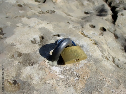 cadenas accroché dans la roche via un U scellé