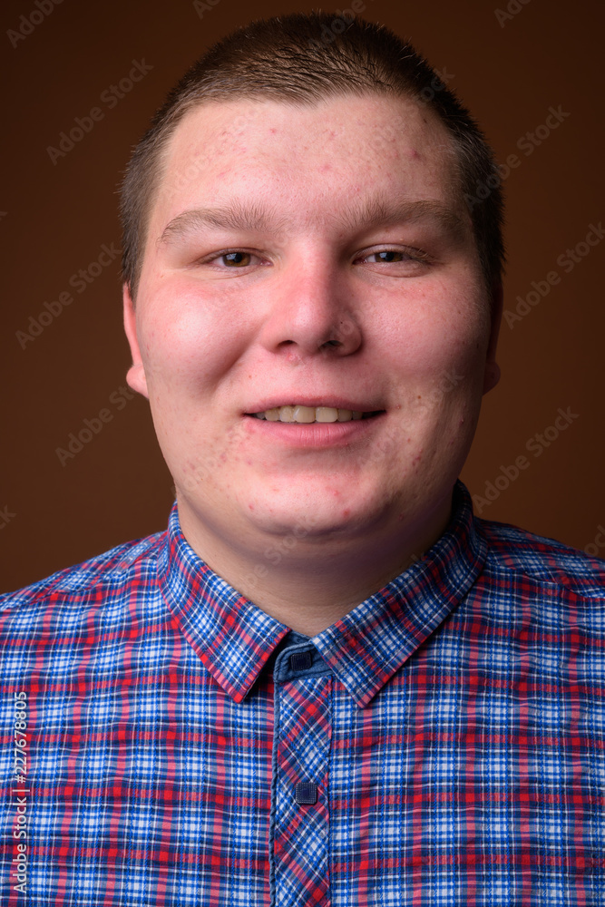 Obraz premium Studio shot of overweight young man against brown background