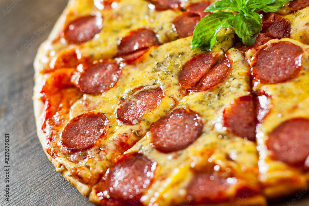 Pepperoni Pizza with Mozzarella cheese, salami, Tomato sauce, pepper, Spices and Fresh Basil. Italian pizza on wooden background Pepperoni Pizza with Mozzarella cheese, salami, Tomato sauce, pepper, Spices and Fresh Basil. Italian pizza on wooden background