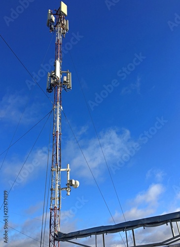 cell tower on the roof of the building against the blue sky