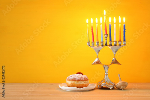 image of jewish holiday Hanukkah background with traditional menorah (traditional candelabra) and burning candles.