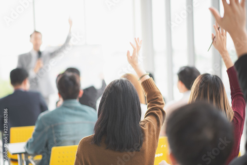 Seminar group raising up hand for asking the speaker that allow to raising up hand in question and answer time in meeting room back side