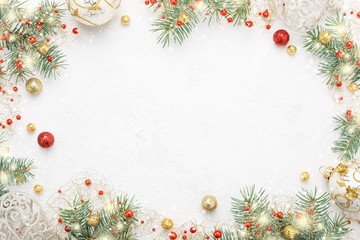 Christmas frame of spruce, red and gold decorations on white background. Copy space. New Year lights. Flat lay.