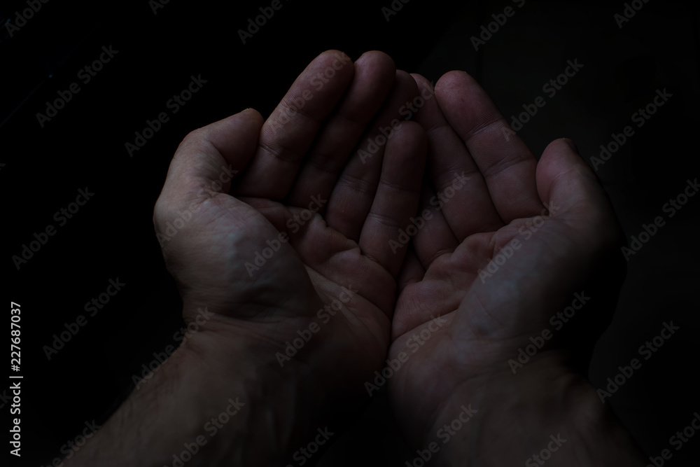 Two hands of man in black background Two hands of man in black background