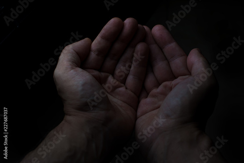 Two hands of man in black background