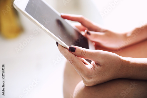 Female hand with tablet trading stock online in coffee shop , Business concept