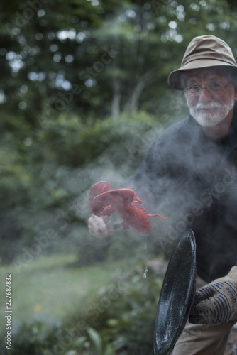 A man cooking lobsters outside  photo