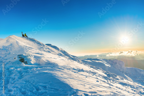 Two people looking at sunset from the top of winter mountain with snow  © Pavlo Vakhrushev