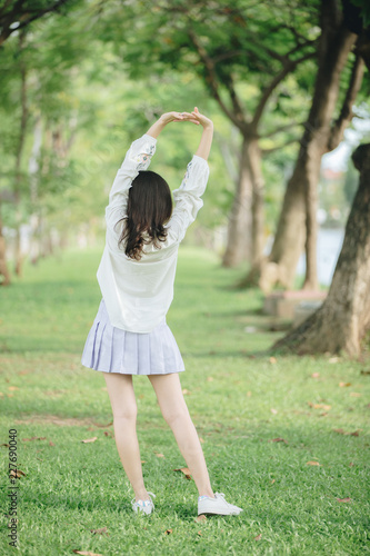 portrait of asian girl with white shirt and skirt looking in outdoor nature vintage film style © Oran Tantapakul