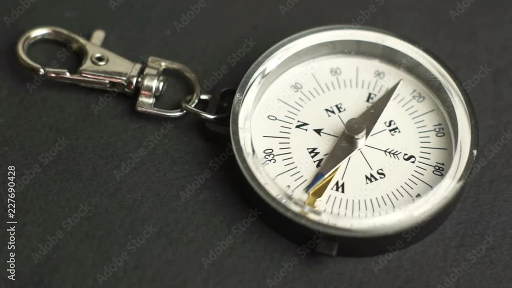 Woman puts on the table key chain compass Woman puts on the table key chain compass