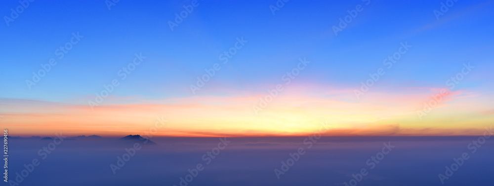 Beautiful colorful sunset at the edge of the Alps with some mountains sticking out of the haze (Bavaria, Germany). Copy space for multiple purposes.