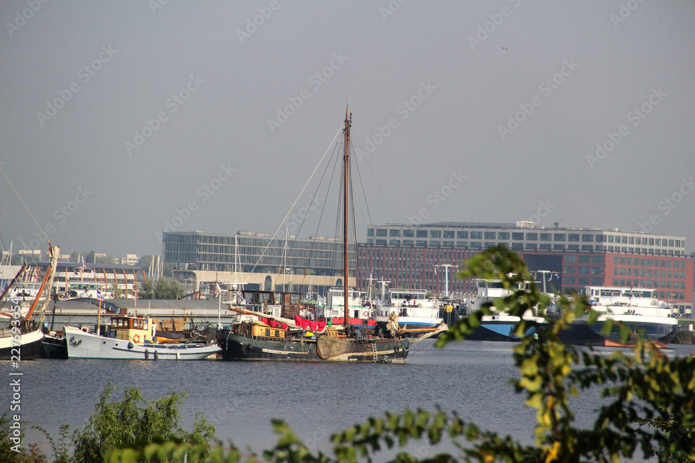 nahansicht auf ein segelboot und weitere schiffe im hafen in amsterdam niederlande fotografiert während einer sightseeing tour in amsterdam niederlande