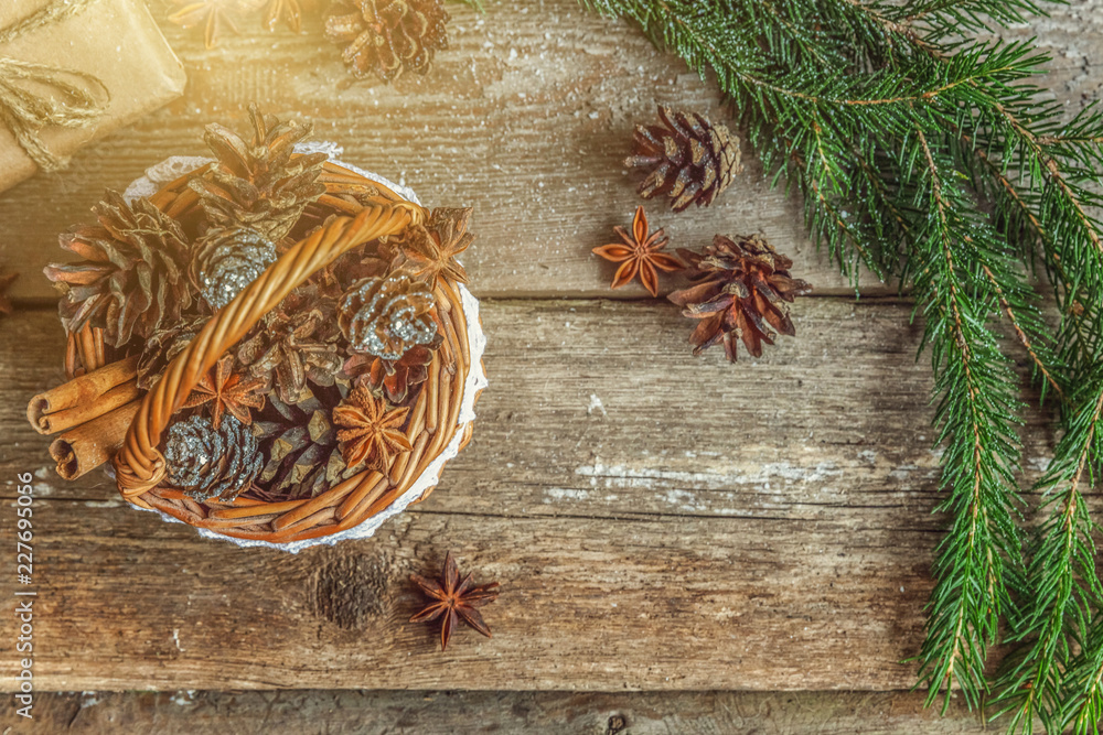 Obraz premium Christmas New Year composition with gift box fir branch basket pine cones on old shabby rustic wooden background. Xmas holiday december decoration to Russian tradition. Flat lay, copy space