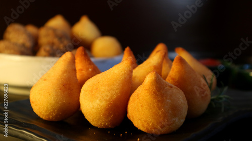 Coxinhas Brazilian snack stuffed with chicken on dark background. Traditional party food.